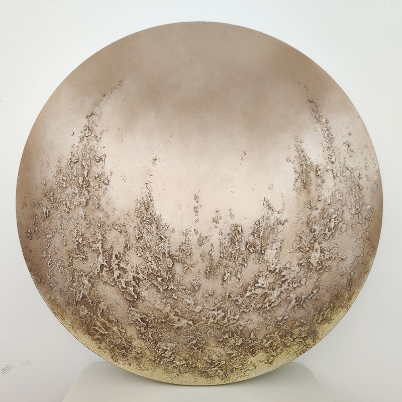 Pyöreä beige abstrakti maalaus, jossa on hieman kultaista.